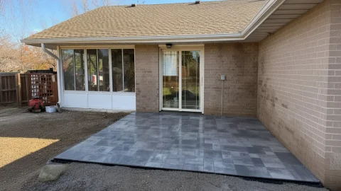 Newly installed gray paver patio at a Cedar Falls brick ranch