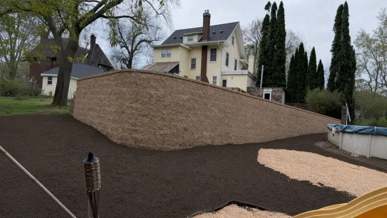New block retaining wall holding a graded Iowa backyard