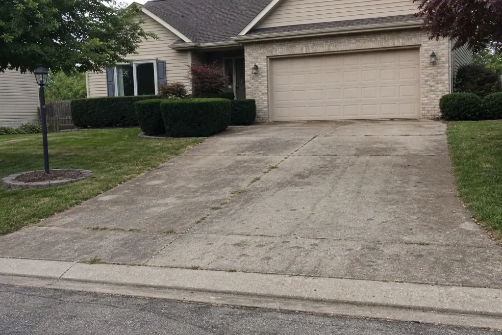 Worn concrete driveway before paver upgrade