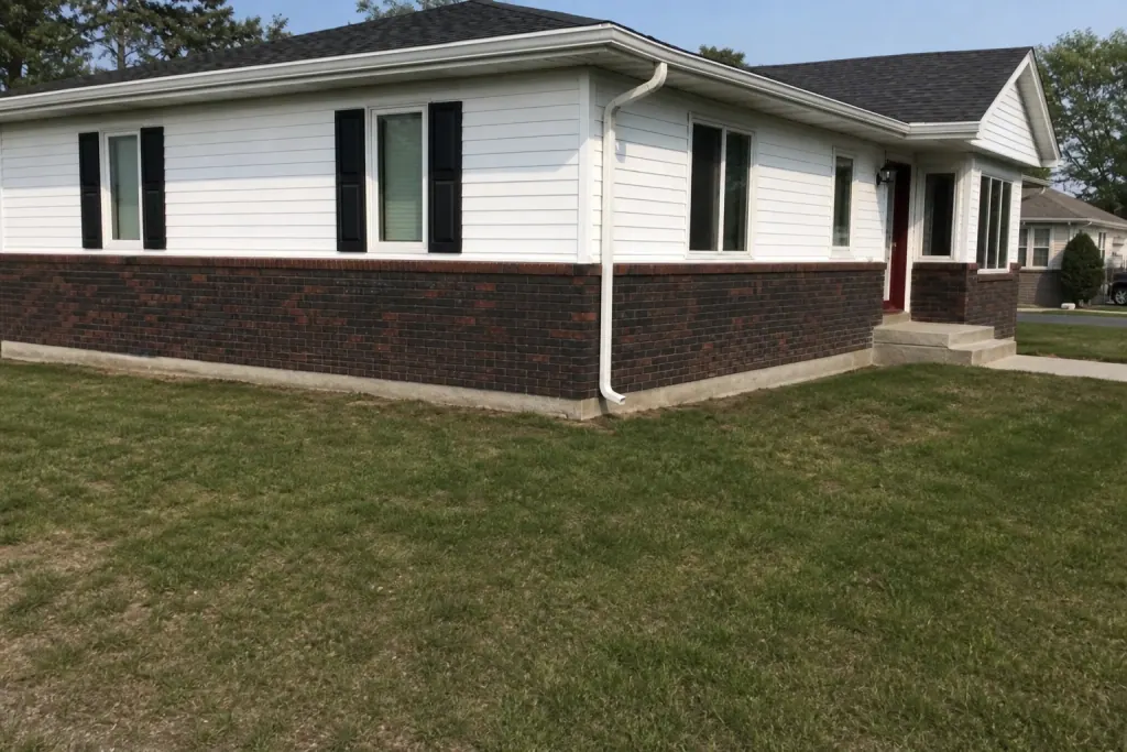Plain grass at house corner before landscape bed installation