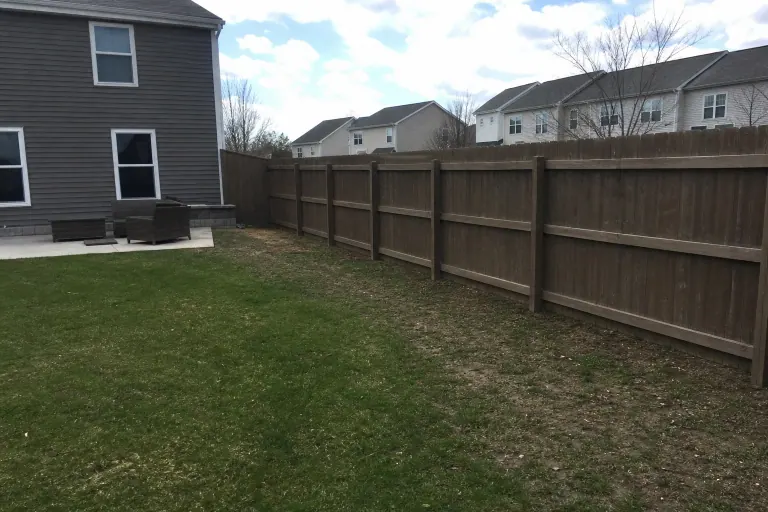 Plain grass along privacy fence before landscape bed installation