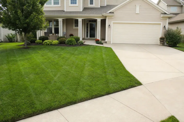 Freshly mowed front yard with clean stripes along the driveway and garage