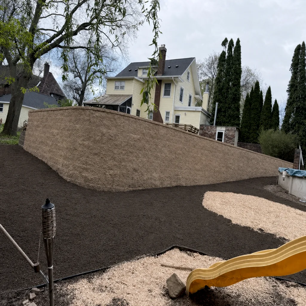 New block retaining wall with graded backyard landscaping