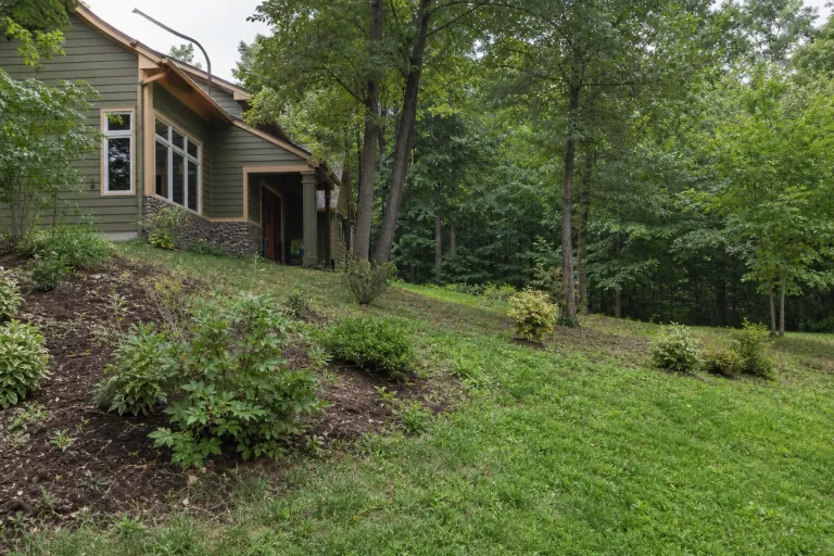 Hillside yard before stone waterfall and pond installation